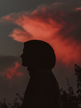 A tranquil silhouette of a woman against a vibrant twilight sky, evoking serenity.. tranquil, silhouette, woman