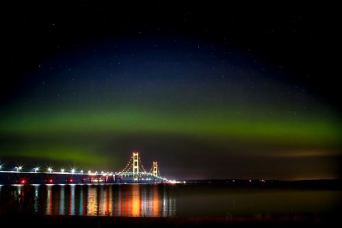 Free Stunning view of the Northern Lights illuminating Mackinac Bridge, Michigan, against a starry sky. Stock Photo