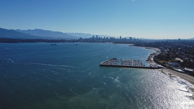 A stunning aerial view of Vancouver's coastline and city skyline on a bright summer day.