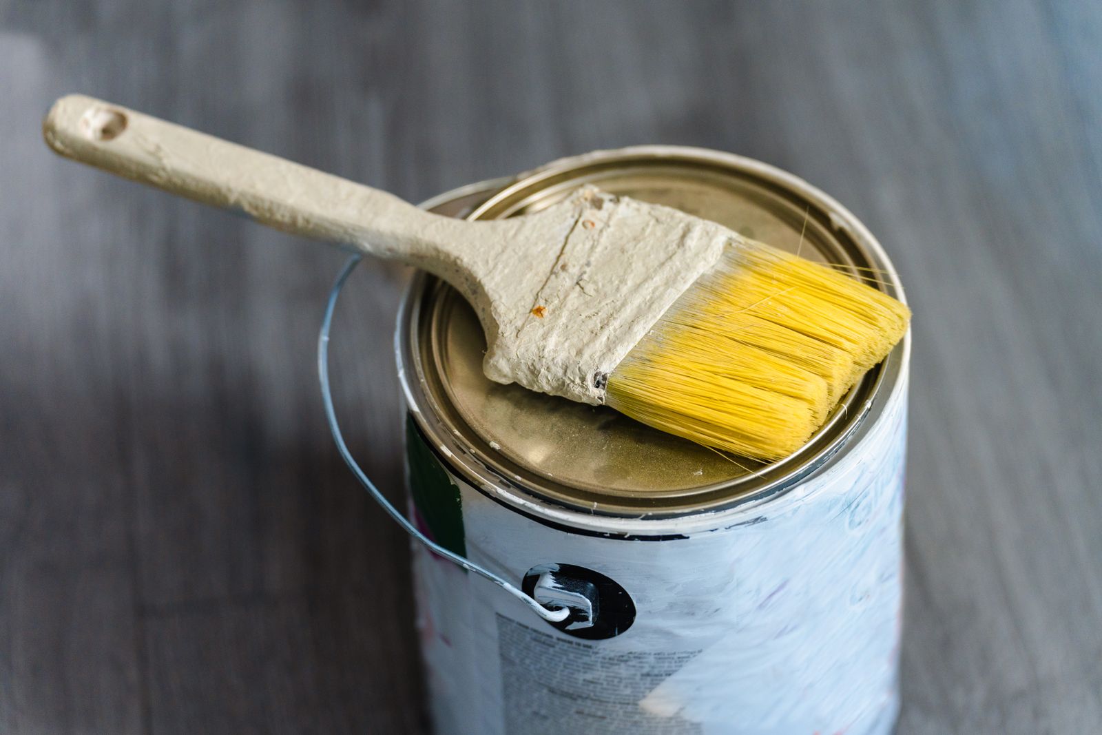 Paint brush resting on the rim of a paint can, ready for cleaning after use