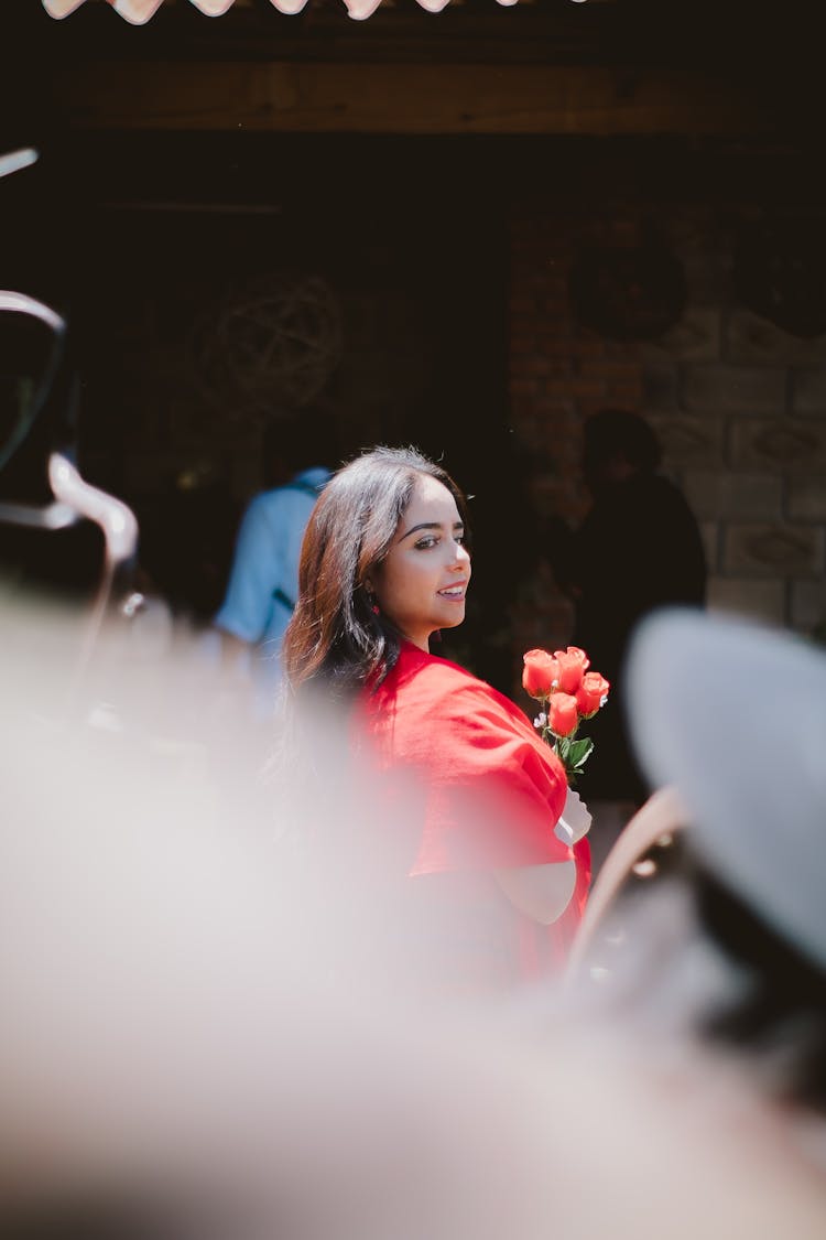 Smiling Woman Holding A Bouquet Of Red Roses