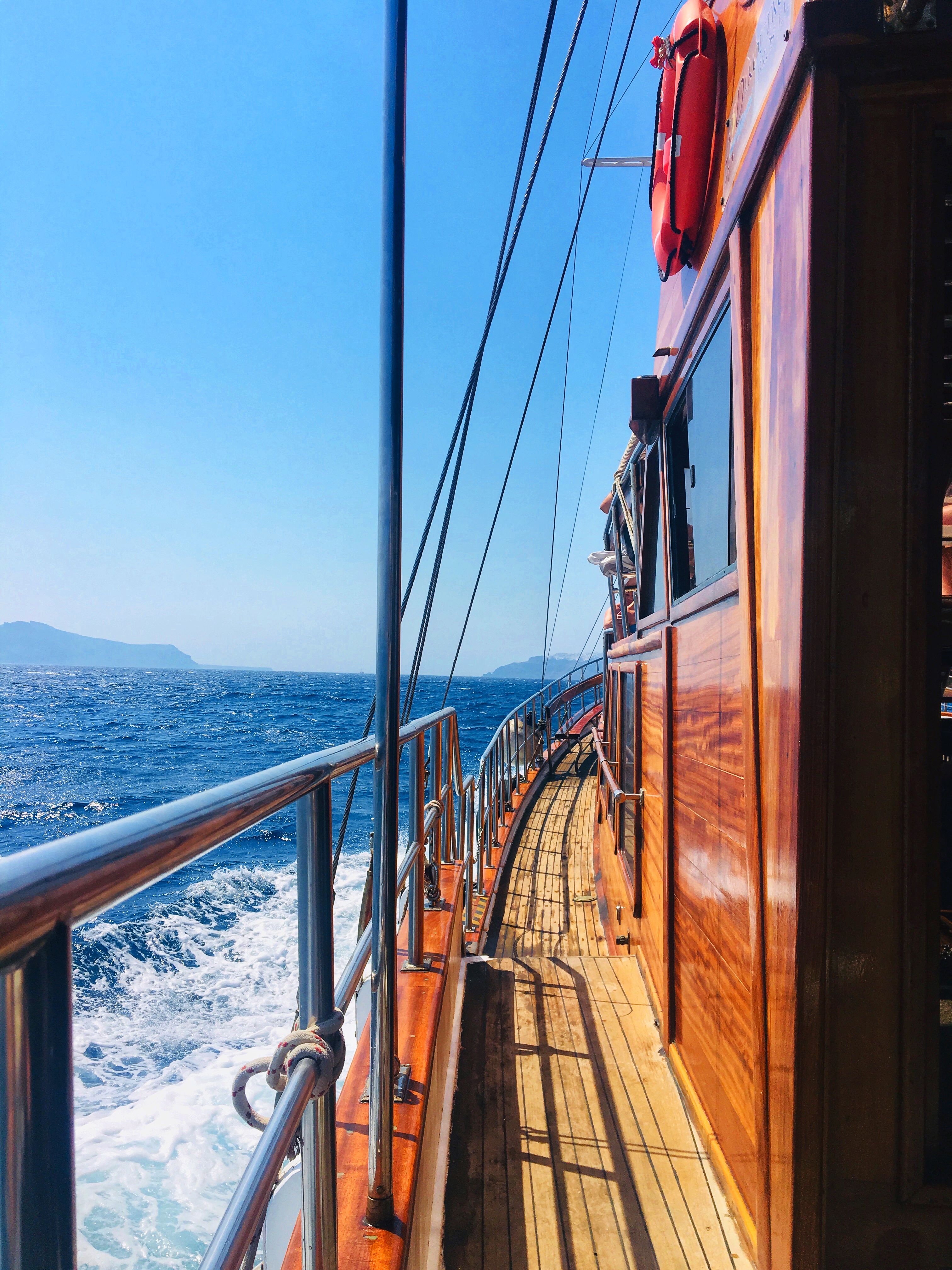 Experience the serene beauty of a sailing trip near Thera, Greece on a classic wooden vessel.
