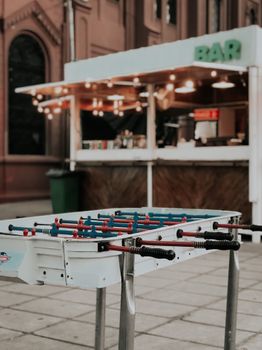 Street foosball table near a cozy bar in Buenos Aires, Argentina, creating a lively urban vibe.