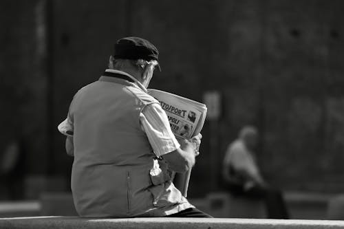 Free Man in Gray Coat Holding a White and Black Box Stock Photo