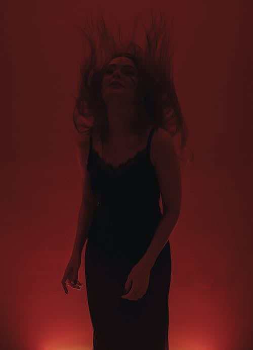 Darmowe zdjęcie z galerii z czarna sukienka, czerwone tło, kobieta