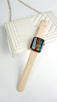 Stylish smartwatch with colorful display resting on a white handbag, perfect for fashion enthusiasts.