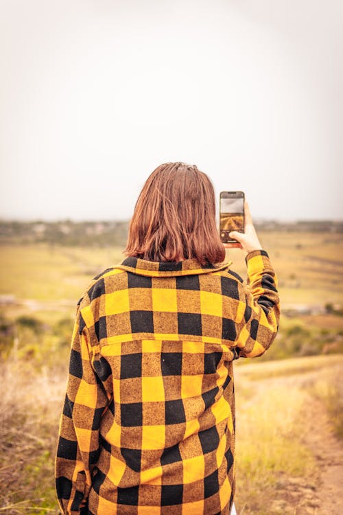 A Woman using Smartphone while Taking Photo