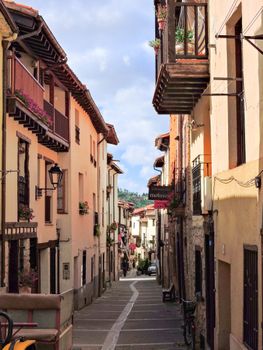 Picturesque narrow street with traditional balconies in Covarrubias, Spain.