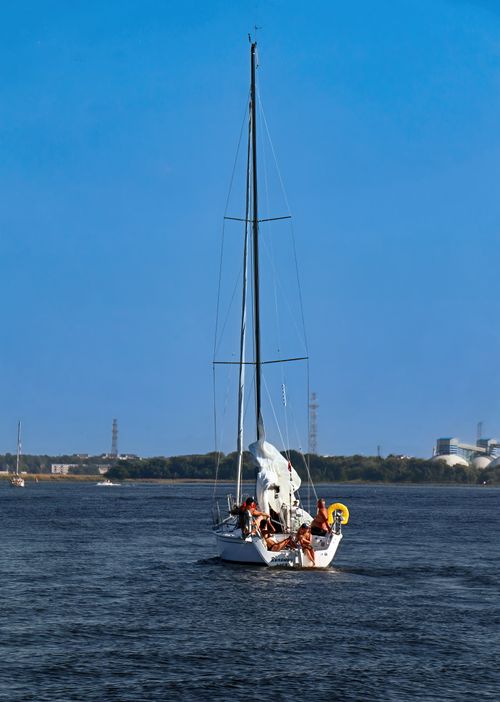 Free A group of people enjoy a day of sailing on a lake under clear blue skies. Stock Photo