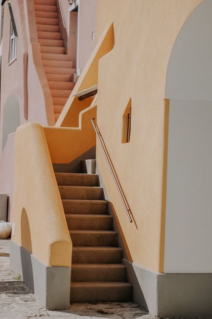 A pastel-colored staircase leading up the side of a Mediterranean-style building.