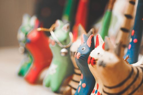 Free A charming display of colorful wooden cat figurines with soft focus effect. Stock Photo