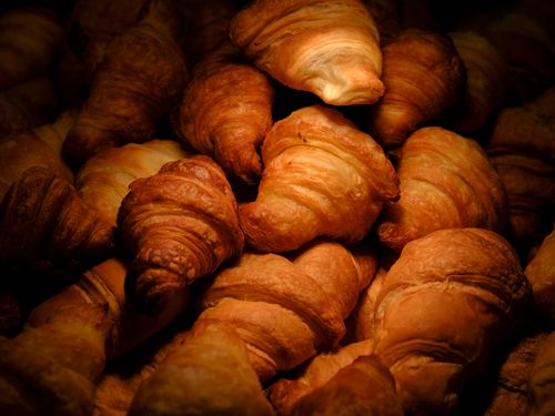 Free A mouth-watering close-up of golden, freshly baked croissants stacked together, tempting ready to eat. Stock Photo