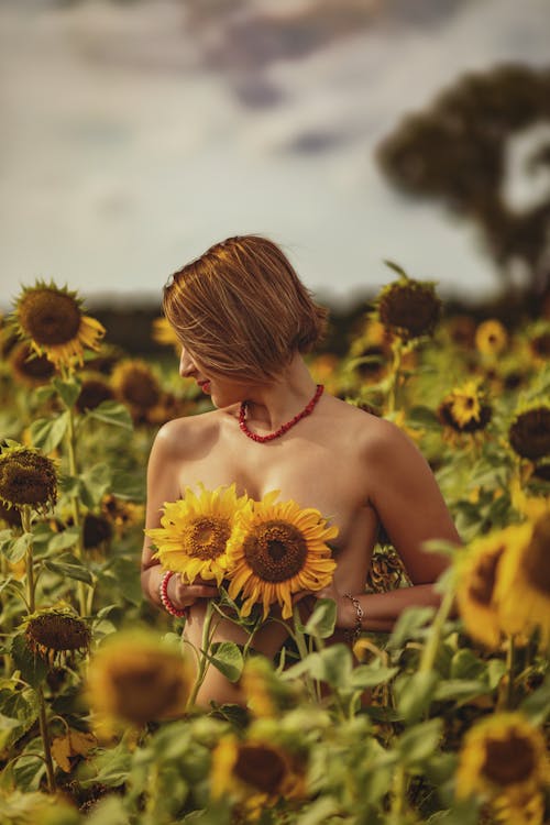 Free Woman in Pink Tank Top Holding Sunflower Stock Photo