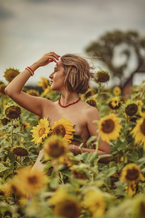 Free Woman in Pink Tank Top Standing on Sunflower Field Stock Photo