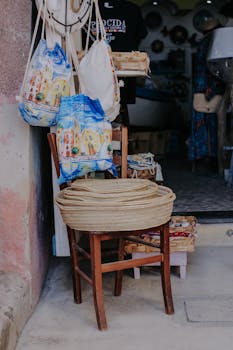 Vibrant market stall showcasing handmade bags and baskets on a wooden chair.