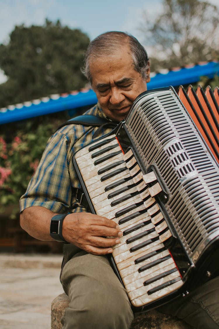 An Elderly Man Playing A Vintage Accordion