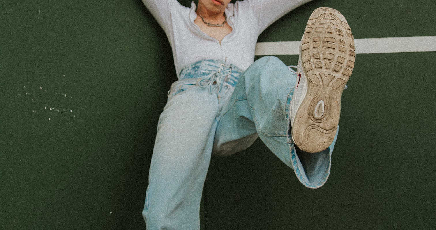 Stylish Girl in Sunglasses Posing near Green Wall