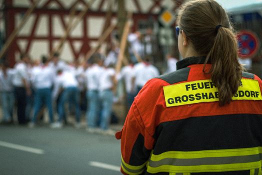 A firefighter in uniform observes a local event, reflecting safety and duty in Großhabersdorf.