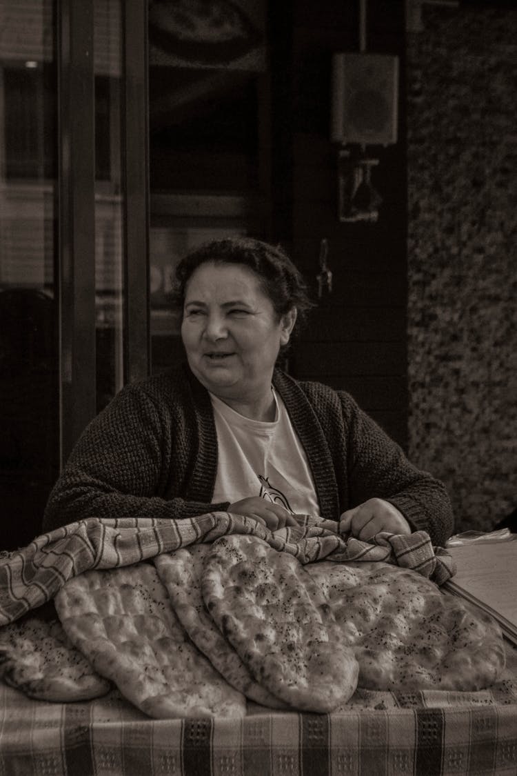 A Woman Selling Food At A Market Stall