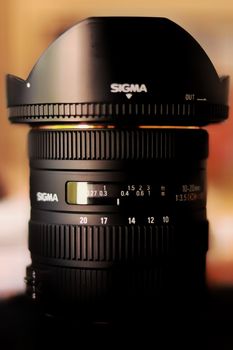 Detailed view of a Sigma lens, showcasing its features and design against a warm background.