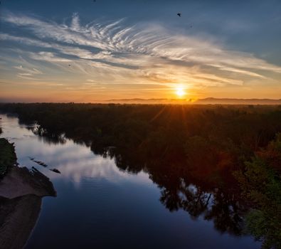 A breathtaking view of the river and forest at sunrise in Trevino, Wisconsin.