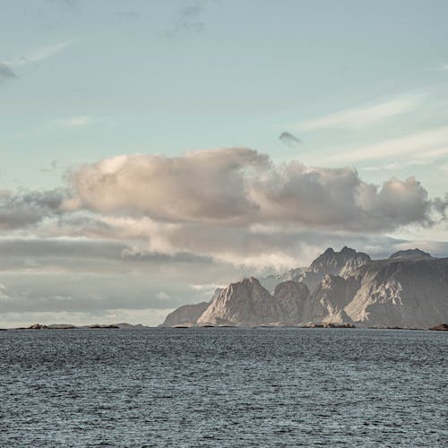 A Rocky Mountain and Sea Under the Cloudy Sky