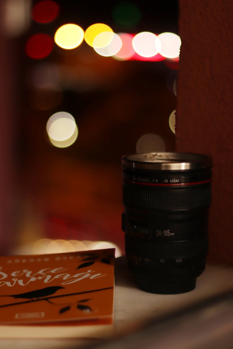 Black Camera Lens Near A Book