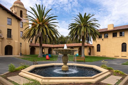 Charming courtyard at Stanford University featuring a fountain and palm trees.