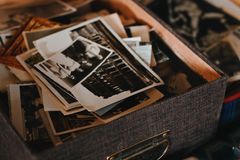 A collection of vintage photographs in a textured box, capturing old memories.
