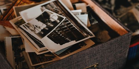 A collection of vintage photographs in a textured box, capturing old memories.