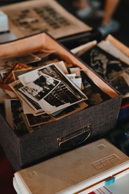 Old photographs stored together — co-authored memory, not solo archive
