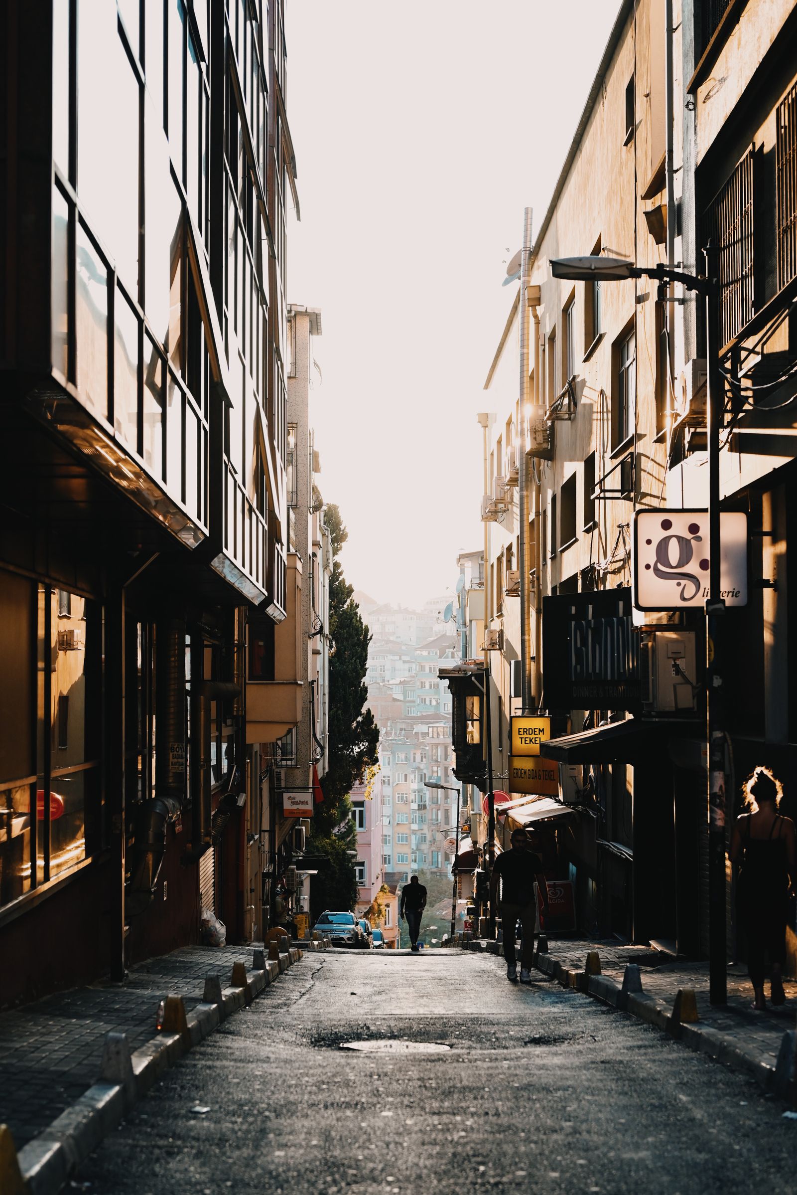 People walking between sunlit buildings on a European street