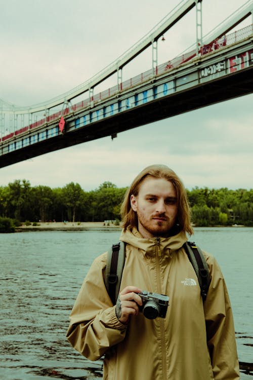 A Man in Brown Jacket Holding a Camera