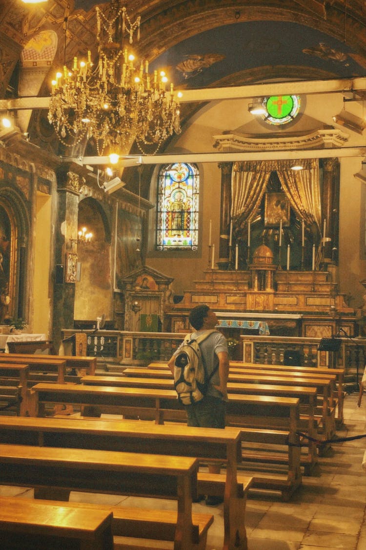 A Man With A Backpack Inside A Church