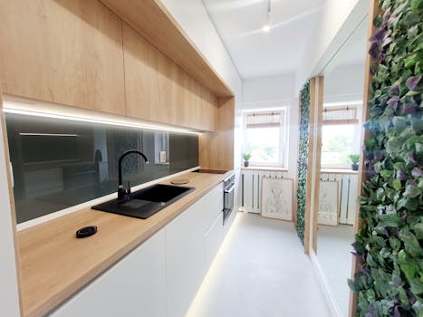 Bright minimalist kitchen with wooden elements and green decor.