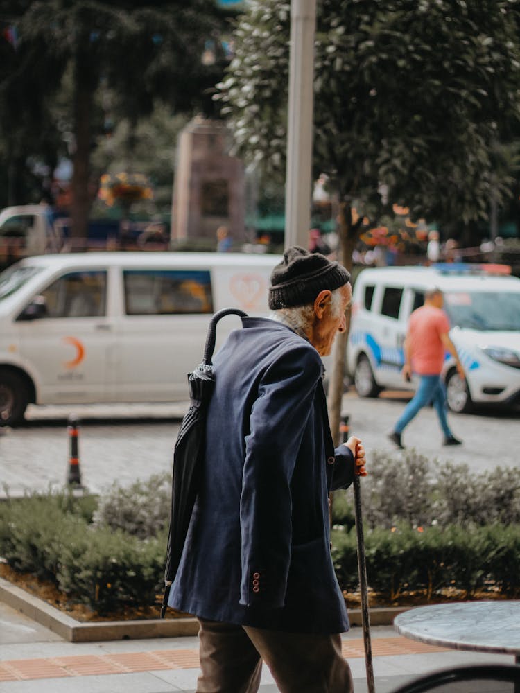 Elderly Man With Umbrella And Cane