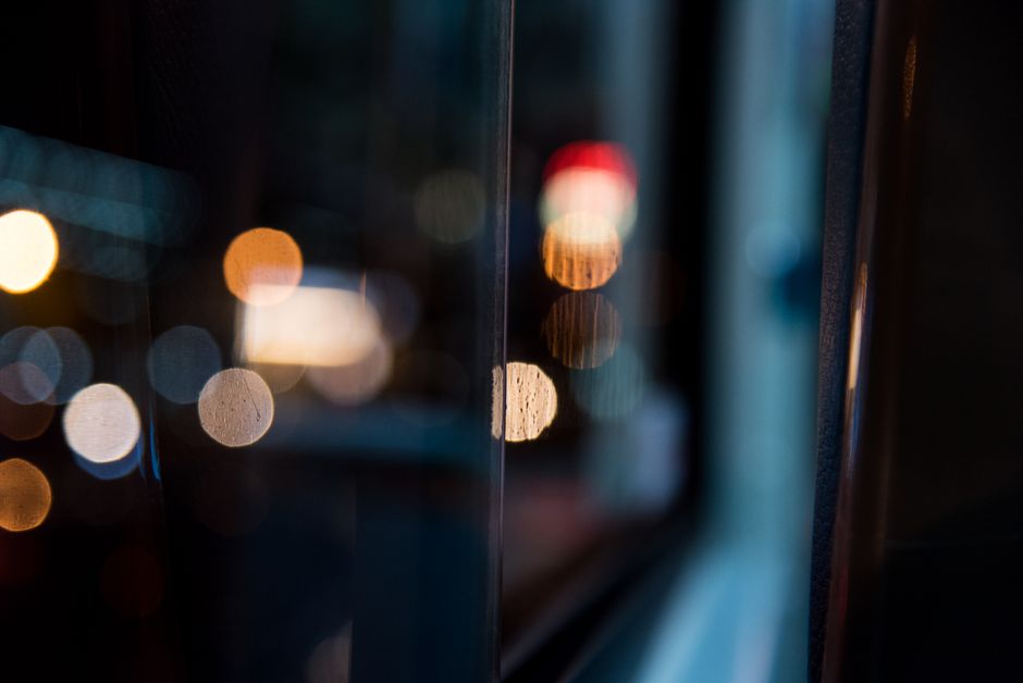Abstract bokeh lights reflected on a glass surface creating a mysterious urban atmosphere.