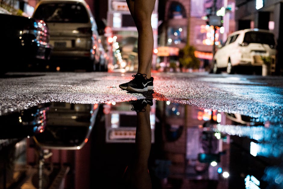 Persons Standing on Asphalt Road Near of Body of Water