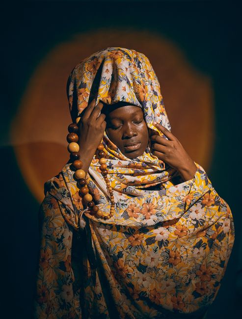 Portrait of an African woman in floral attire, embracing cultural heritage.