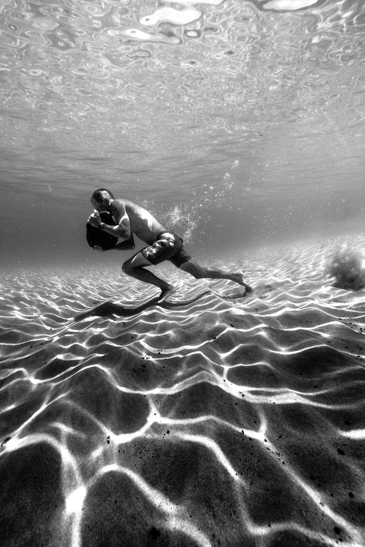 Man Underwater In Black And White