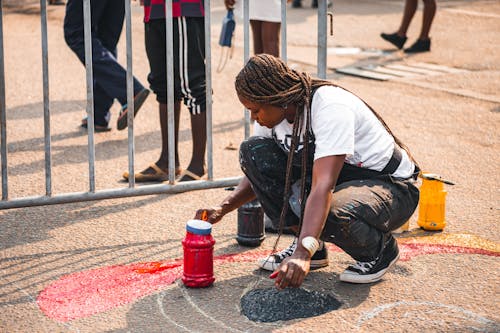 Girl Painting Something on the Sidewalk