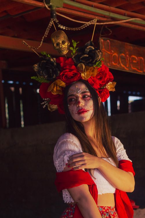 Free Captivating portrait of a woman in traditional Dia de los Muertos makeup with a floral headdress. Stock Photo