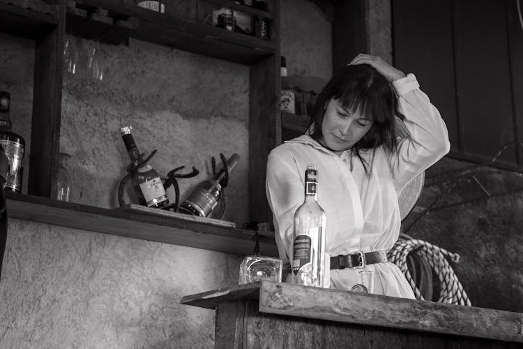 Woman Looking At An Empty Bottle