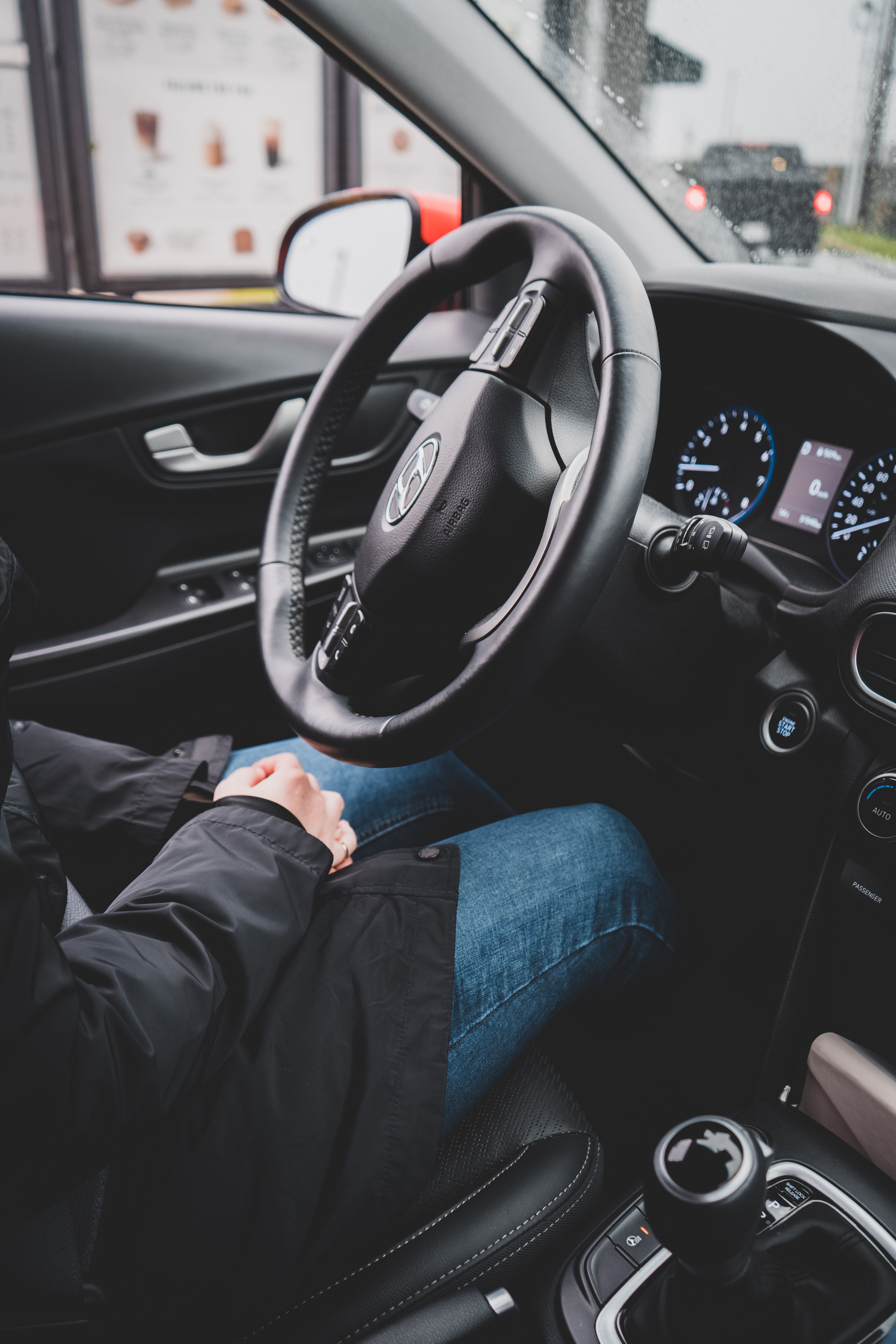 Close-up of a person in a Hyundai car, focusing on the dashboard and steering wheel.