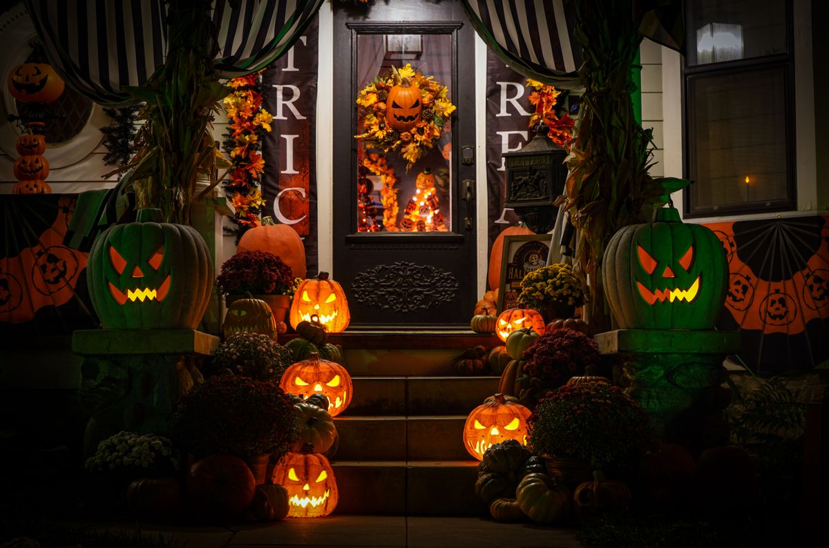 Spooky Halloween porch with glowing jack-o'-lanterns and dark decorations at night