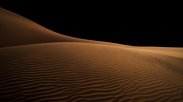 Sand dunes beneath a night sky — photo by Marjan Taghipour on Pexels