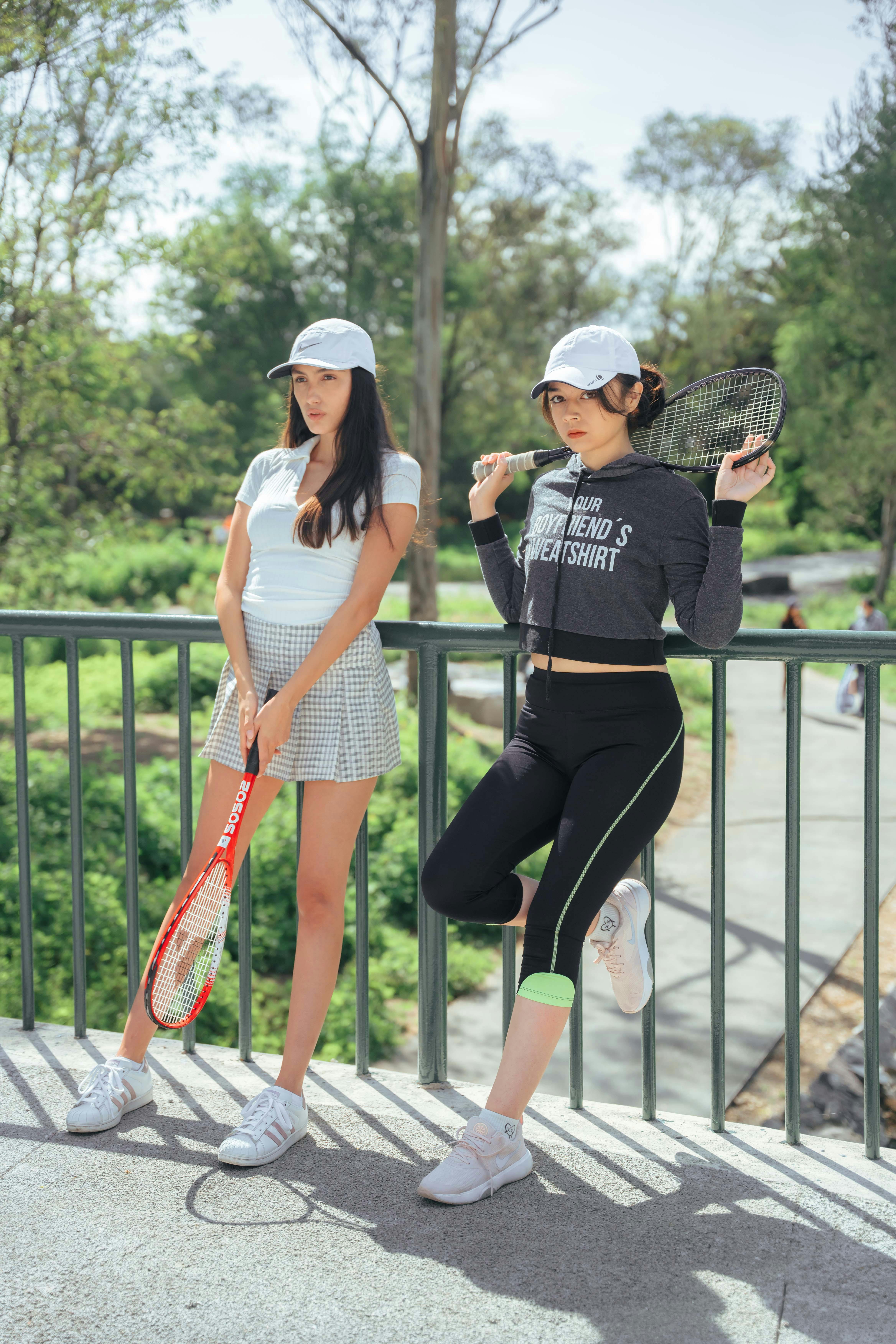 Women Leaning on Metal Railing while Holding a Tennis Racket · Free ...