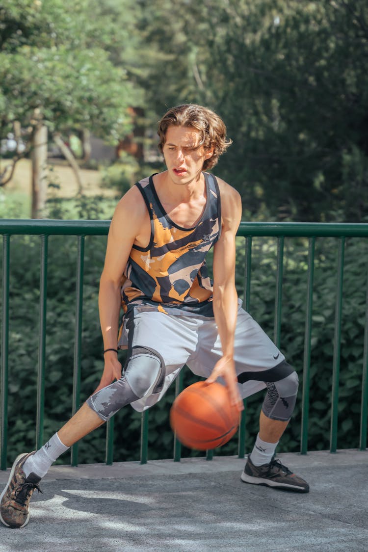 Young Man Playing Basketball Outside 