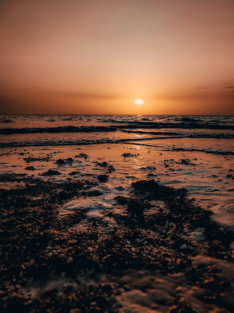 Ocean Waves Crashing On Shore During Sunset