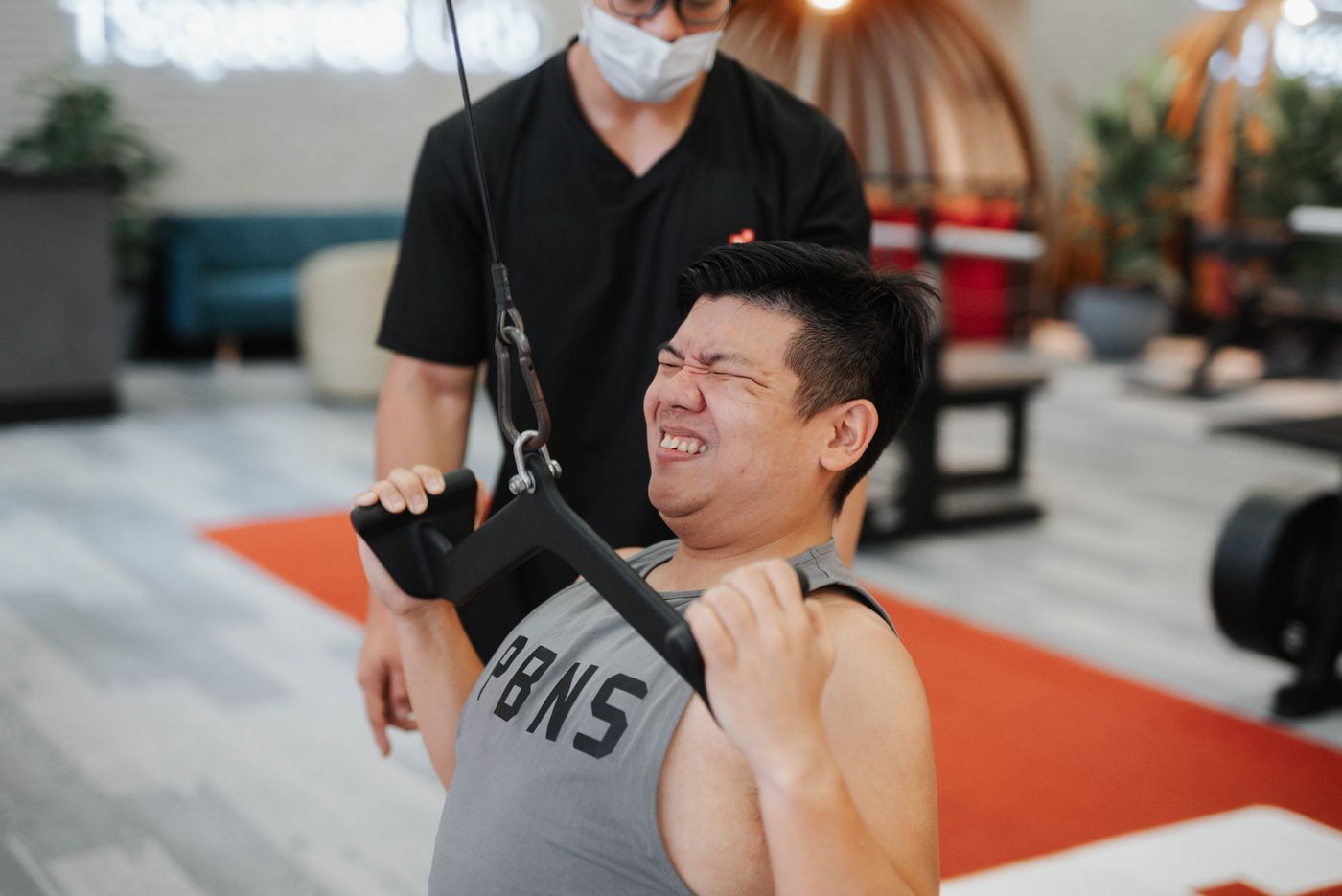 Personal trainer guiding a student during gym training